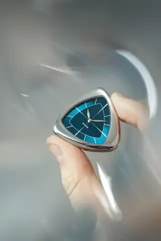 The blue A1 Core case and dial held in the hand.
