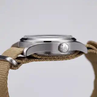 Side view of the Field Watch 38 case and crown on a fabric strap.