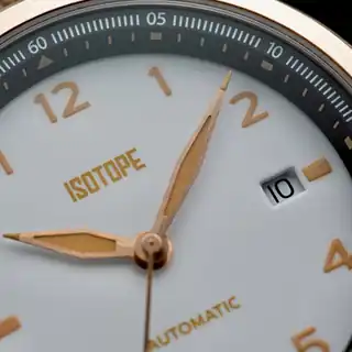 A close view of the white dial, hands and date aperture.