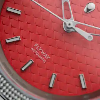 A close view of the coral dial texture and applied markers.